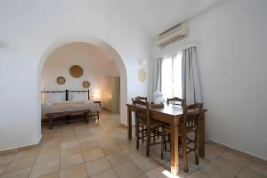a living room with a dining room table and a bed at Kythiris Studios in Kálamos Kythira