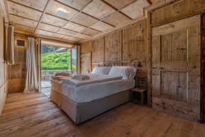 a bedroom with a bed in a room with wooden walls at Dolomites Cesa Del Louf Superior in Arabba