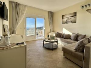 a living room with a couch and a table at EDEM free parking, sea view & pool in Kunje