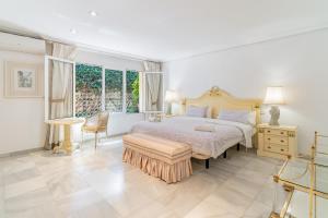 a white bedroom with a bed and a large window at Exclusive Villa El Messidor in Marbella +20 photos