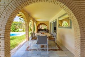 an archway in a patio with a table and chairs at Exclusive Villa El Messidor in Marbella