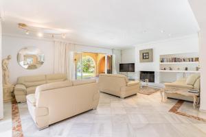 a living room with white furniture and a fireplace at Exclusive Villa El Messidor in Marbella