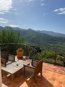 a patio with two benches and a table with a view at la maison CM in Nessa