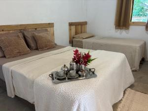 a room with two beds and a tray with flowers on it at Casa natureza Paraty II in Paraty