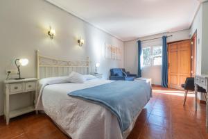 a bedroom with a bed and a desk and a chair at Hotel Rural El Retiro de San Pedro by RetiroRural in Arenas de San Pedro +34 photos