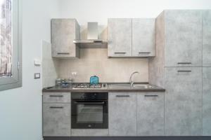 a kitchen with stainless steel cabinets and an oven at Le Quattro Perle Apartments in Pachino