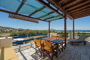 a patio with a table and chairs on a balcony at Maria's Village Suite in Kampos Paros