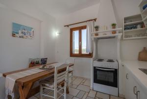 a small kitchen with a table and a stove at Maria's Village Suite in Kampos Paros