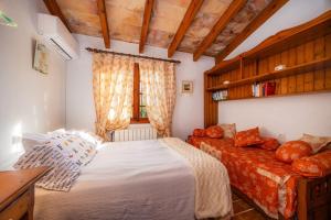 a bedroom with a bed and a couch and a window at Can Bleo in Pollença