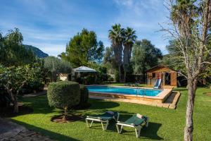a swimming pool in a yard with two lounge chairs at Can Bleo in Pollença