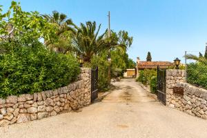 a dirt road in front of a stone wall at Can Bleo in Pollença