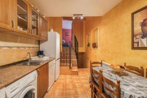 a kitchen with a refrigerator and a table with chairs at El Rellano in Maluenda
