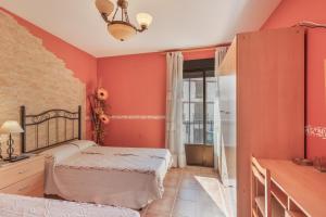 a bedroom with two beds in a room with orange walls at El Rellano in Maluenda