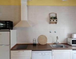 a small kitchen with a sink and a microwave at El Aterpe 4 in Aldehuela del Rincón +9 photos