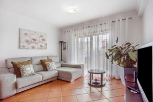 a living room with a couch and a tv at Casa da Cândida in Nazaré
