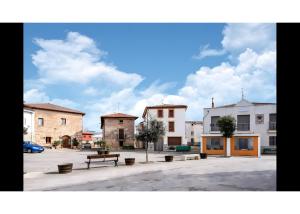 a park with a bench in a parking lot with buildings at Casa Llano in Llano de Bureba