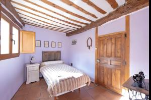 a bedroom with a bed and a wooden door at Casa Llano in Llano de Bureba
