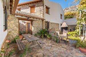 a patio with a wooden table and a building at Cortijo El Plantío Castril in Castril