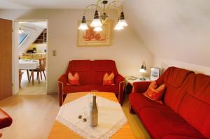 a living room with two red couches and a table at Ferienwohnung Härtel in Bad Zwischenahn