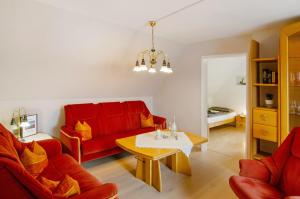 a living room with a red couch and a table at Ferienwohnung Härtel in Bad Zwischenahn