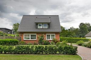a red brick house with a gray roof at Ferienwohnung Härtel in Bad Zwischenahn