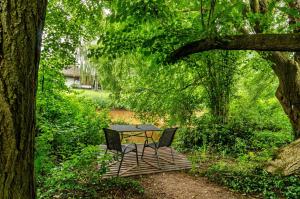 a table and two chairs sitting on a bench under a tree at Fewo3 Buppeape Saterland in Bollingen