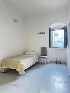 a white room with a bed and a chair at Casa Vacanze Flora in Peschici