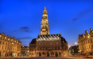 a large building with a clock tower at night at Grand Gîte Avec 2 Chambres in Saint-Pol-sur-Ternoise +3 photos