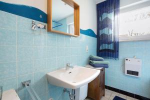 a blue tiled bathroom with a sink and a mirror at Bikerhäusle in Gerstetten +23 photos