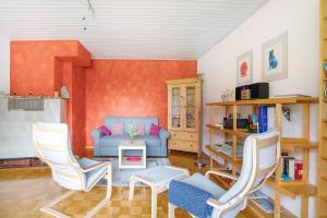 a living room with a blue couch and two chairs at Bikerhäusle in Gerstetten