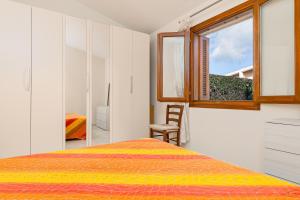 a bedroom with a bed and a window at Villetta Lu Lioni in San Teodoro