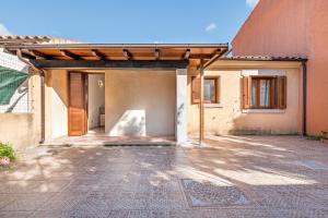 an entrance to a house with a wooden pergola at Villetta Lu Lioni in San Teodoro