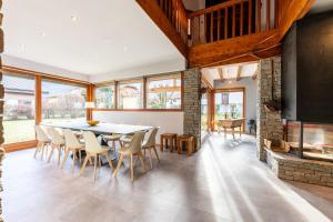 a dining room with a table and chairs and a fireplace at chalet pierre et bois in Aigueblanche