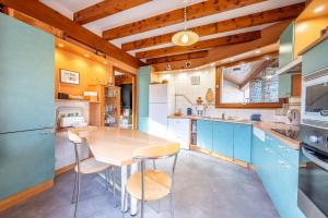 a kitchen with blue cabinets and a wooden ceiling at chalet pierre et bois in Aigueblanche