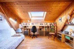 a room with a bed and a desk and a window at chalet pierre et bois in Aigueblanche