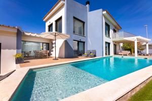 a villa with a swimming pool in front of a house at Villa La Primera in Llucmajor