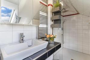 a white bathroom with a sink and a shower at Ferienwohnung Romanu in Winzeln