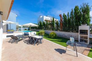 a patio with a table and chairs and a pool at Villa La Primera in Llucmajor