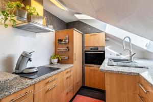 a kitchen with wooden cabinets and a sink at Ferienwohnung Romanu in Winzeln +15 photos