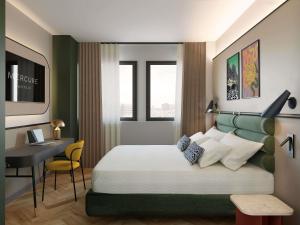 a bedroom with a bed and a desk and a table at Mercure Milano Agrate Brianza in Agrate Brianza