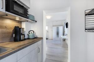 a kitchen with white cabinets and a counter top with a sink at Friesenstube in Kerken