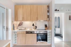 a kitchen with wooden cabinets and a stove at Idyllic Lakeside Cottage in Bockhorn