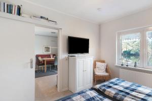 a bedroom with a bed and a flat screen tv at Idyllic Lakeside Cottage in Bockhorn