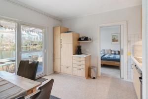 a kitchen with a table and a bedroom with a bed at Idyllic Lakeside Cottage in Bockhorn