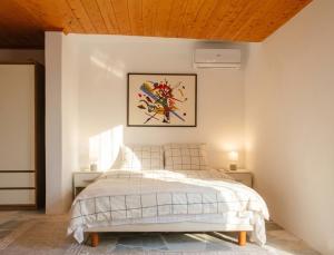 a bedroom with a bed with a wooden ceiling at The Beach White House - 80m from the Beach - Renovated in Áyios Yeóryios