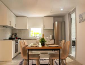 a kitchen with a table with chairs and a refrigerator at The Beach White House - 80m from the Beach - Renovated in Áyios Yeóryios