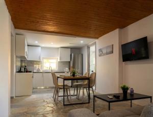 a kitchen and living room with a table and chairs at The Beach White House - 80m from the Beach - Renovated in Áyios Yeóryios +12 photos
