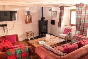 a living room with two couches and a wood stove at Le Cottage des Pléiades in Les Angles