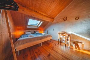 a bedroom with a bed and a chair in a attic at Le Cottage des Pléiades in Les Angles +72 photos