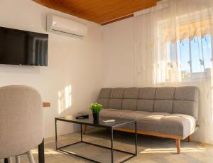 a living room with a couch and a table at The Beach White House - 80m from the Beach - Renovated in Áyios Yeóryios